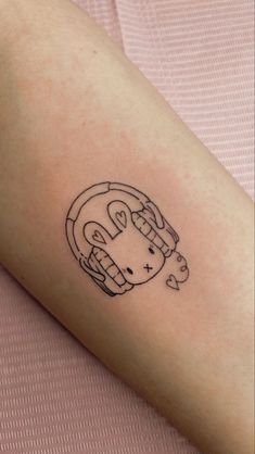 a small tattoo on the arm of a woman with a cat in a wheel design