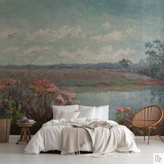 a bedroom with a large painting on the wall and white bedding in front of it