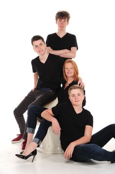 a group of people sitting on top of a white toilet in front of a white background