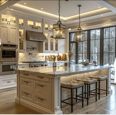 a large kitchen with an island in the middle and several stools on the side