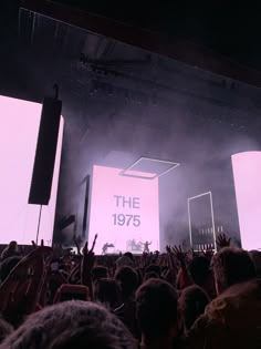 a large group of people standing on top of a stage with their hands in the air