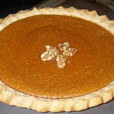 a pumpkin pie sitting on top of a metal pan