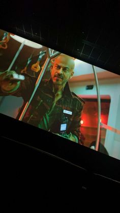 a man is on a large screen in the dark