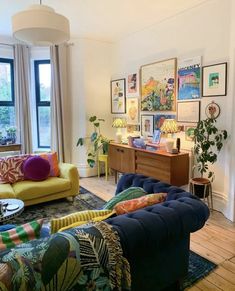 a living room filled with lots of furniture and decor on top of wooden flooring