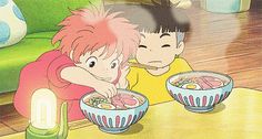 two children eating food from bowls on a table