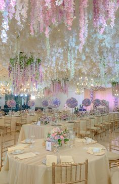 an elaborately decorated banquet hall with flowers hanging from the ceiling