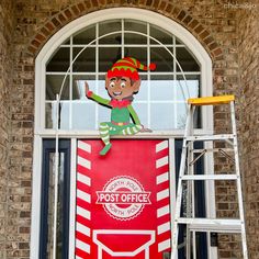 an elf on top of a post office sign in front of a brick building with a ladder