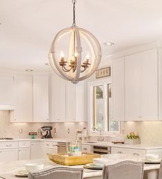 a kitchen with white cabinets and a chandelier hanging from the ceiling