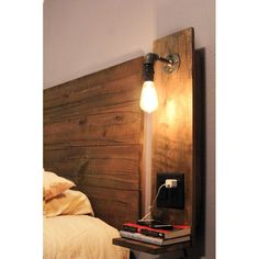 a wooden headboard with a light on it next to a bed