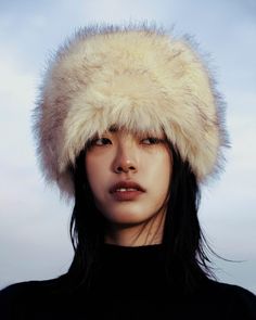 a woman wearing a fur hat and black shirt