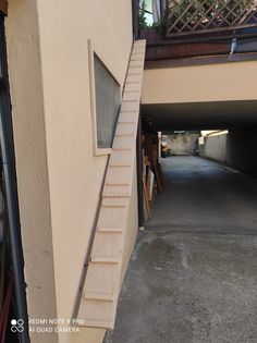 an alley way with stairs leading up to the second floor