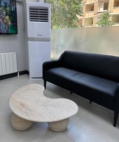 a living room with a couch, table and air conditioner