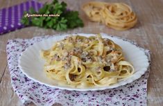 a white plate topped with pasta covered in meat and sauce next to some parsley