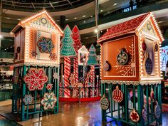 brightly lit gingerbread houses on display in an indoor mall