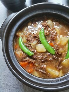 a bowl filled with meat and vegetables on top of a table