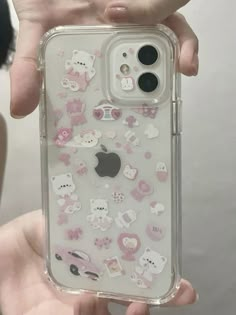 someone holding up their phone case with hello kitty stickers on it