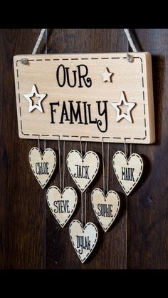 a wooden sign that says our family with hearts and stars hanging from the side of it