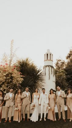 a group of people standing next to each other in front of a tall white tower