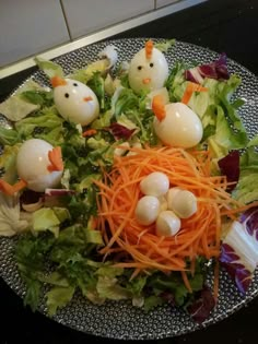 a plate topped with lettuce and carrots covered in fake chicken heads on top of it