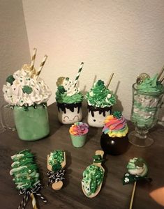 some cupcakes and marshmallows are on a table with green decorations