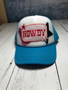 Elevate your casual style with this eye-catching "Howdy" Trucker Hat! Featuring a vibrant blue and white color scheme, this hat is perfect for adding a touch of western flair to your outfit. The front panel showcases a bold embroidered "Howdy" text with pink star accents, adding a playful and trendy touch. Key Features: Unique Design: Embroidered "Howdy" text with pink and red detailing and star accents. Comfortable Fit: Mesh back for breathability and a snapback closure for an adjustable fit. Durable Materials: Made from high-quality fabric for long-lasting wear. Versatile Style: Perfect for casual outings, outdoor activities, or adding a fun element to your everyday look. Whether you're heading to a country music concert, a summer BBQ, or just out and about, this hat is sure to turn head Casual Blue Hats For Rodeo, Trendy Blue Hat For Rodeo, Blue Country Style Hat, Country Style Blue Hat, Blue Country Hat With Curved Brim, Blue Country Style Hat With Curved Brim, Country Style Blue Hat With Curved Brim, Blue Snapback Trucker Hat For Rodeo, Blue Snapback Hat For Rodeo