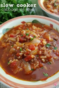 two bowls of slow cooker cabbage roll soup on a table with parsley in the background