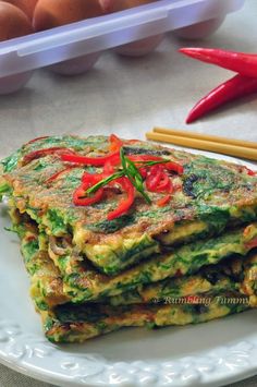 there is a stack of food on the plate next to some eggs and chopsticks