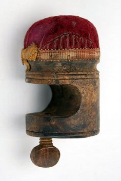 an old wooden object with a red hat on it