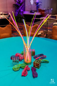 there are many glasses on the table with straws in each glass and one is colorful