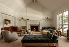 a living room filled with furniture and a fire place in the middle of the room