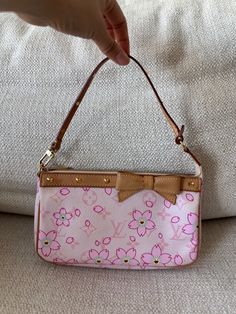 This is a gorgeous vintage 2003 Louis Vuitton X Takashi Murakami Limited Edition pink monogram with cherry blossoms pochette. Featuring vachetta leather trim with brass spike details on handle and trim, a vachetta leather bow detail and brass zipper closure with beige suede interior. I’m the original owner of this bag and I purchased it from a Louis Vuitton boutique in Paris.  Serial Number: AR0043 Year: 2003 Measurements: Length: 8.5”, Depth: 1.5”, Height: 5”, Handle Drop: 5.5” Material: Canvas & Leather Color: Pink Hardware: Brass Item Condition: Pre-Owned - Excellent Comes with original dust bag and original box Louis Vuitton Cherry Blossom Bag, Libra Style, Louis Vuitton Cherry Blossom, Louis Vuitton Takashi Murakami, Fem Outfits, Louis Vuitton Murakami, Pretty Purses, Pink Cherry Blossom, Pink Monogram