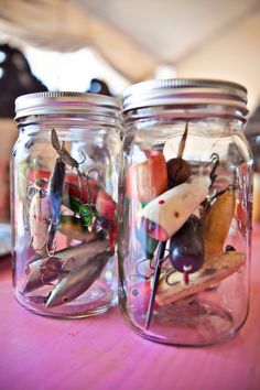 two glass jars filled with different types of buttons