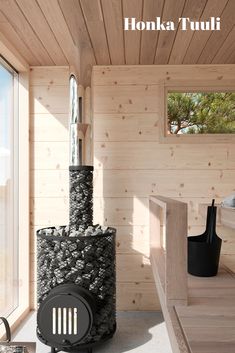 the interior of a wooden cabin with a black and white stove in front of a window