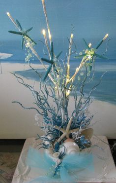 a vase filled with branches and lights on top of a table