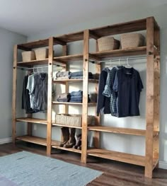 an open closet with clothes and baskets on the shelves in front of it, next to a rug