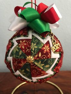 a christmas ornament on a stand with ribbon