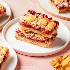 three pieces of dessert sitting on top of a white plate next to crackers and chips