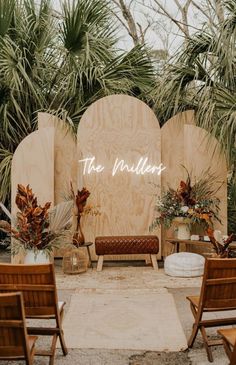 an outdoor ceremony setup with wooden chairs and palm trees