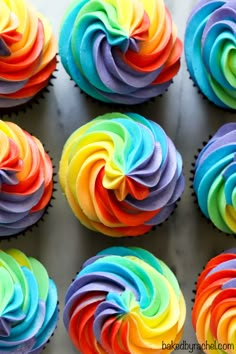 cupcakes with rainbow frosting are arranged in rows