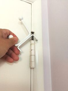 a person is opening the door with two screws on each side and an object in the middle