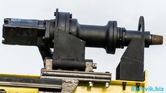 an old looking telescope mounted on top of a yellow vehicle with the sky in the background