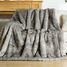 a large gray blanket sitting on top of a wooden floor