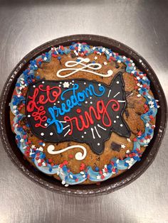 a decorated cookie in the shape of a cat on top of a metal plate with writing