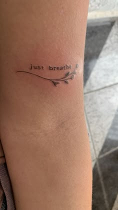 a woman's arm with a tattoo saying just breathe