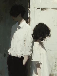 two people standing next to each other in front of a white wall with black hair