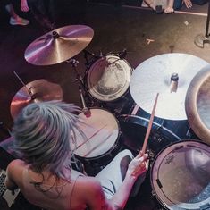 a woman playing drums in front of a laptop