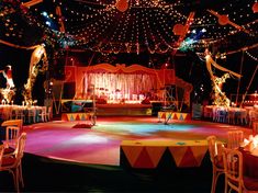 an elaborately decorated dance floor is lit up with colorful lights and draping