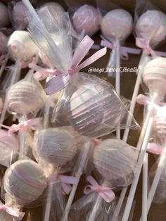 there are many lollipops wrapped in cellophane and tied with pink ribbon