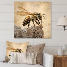 two bees sitting on top of a rock in front of a wall mounted art piece