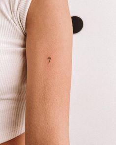 a woman's arm with a small tattoo on the left side of her arm